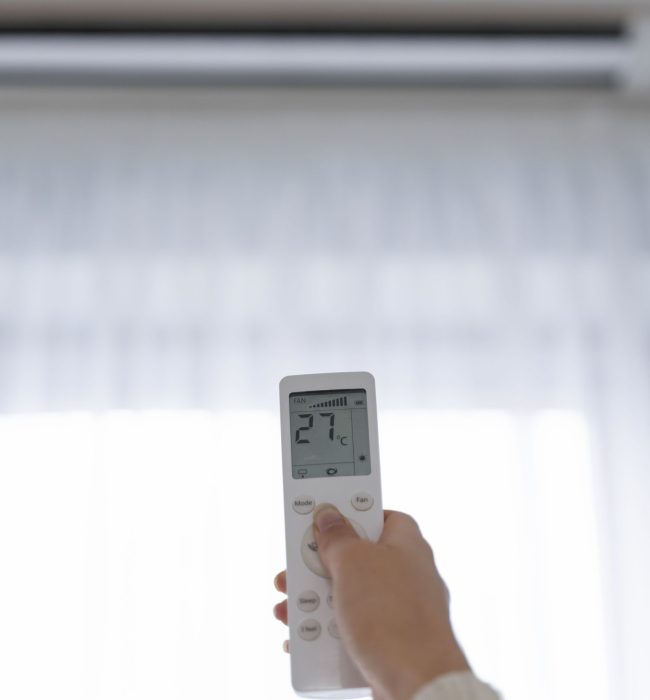 mano-sujetando-el-mando-distancia-para-encender-el-calentador